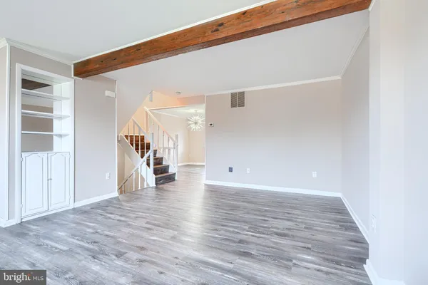 a view of empty room with wooden floor