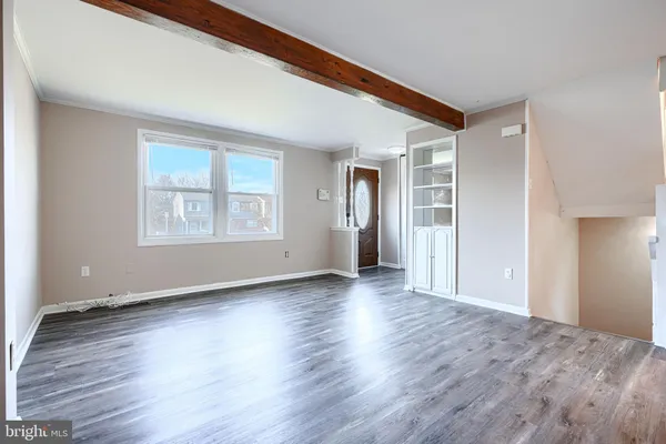 a view of a big room with wooden floor and windows