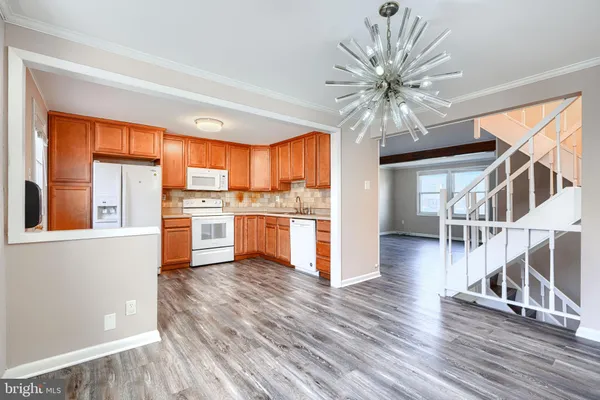 a kitchen with cabinets and wooden floor