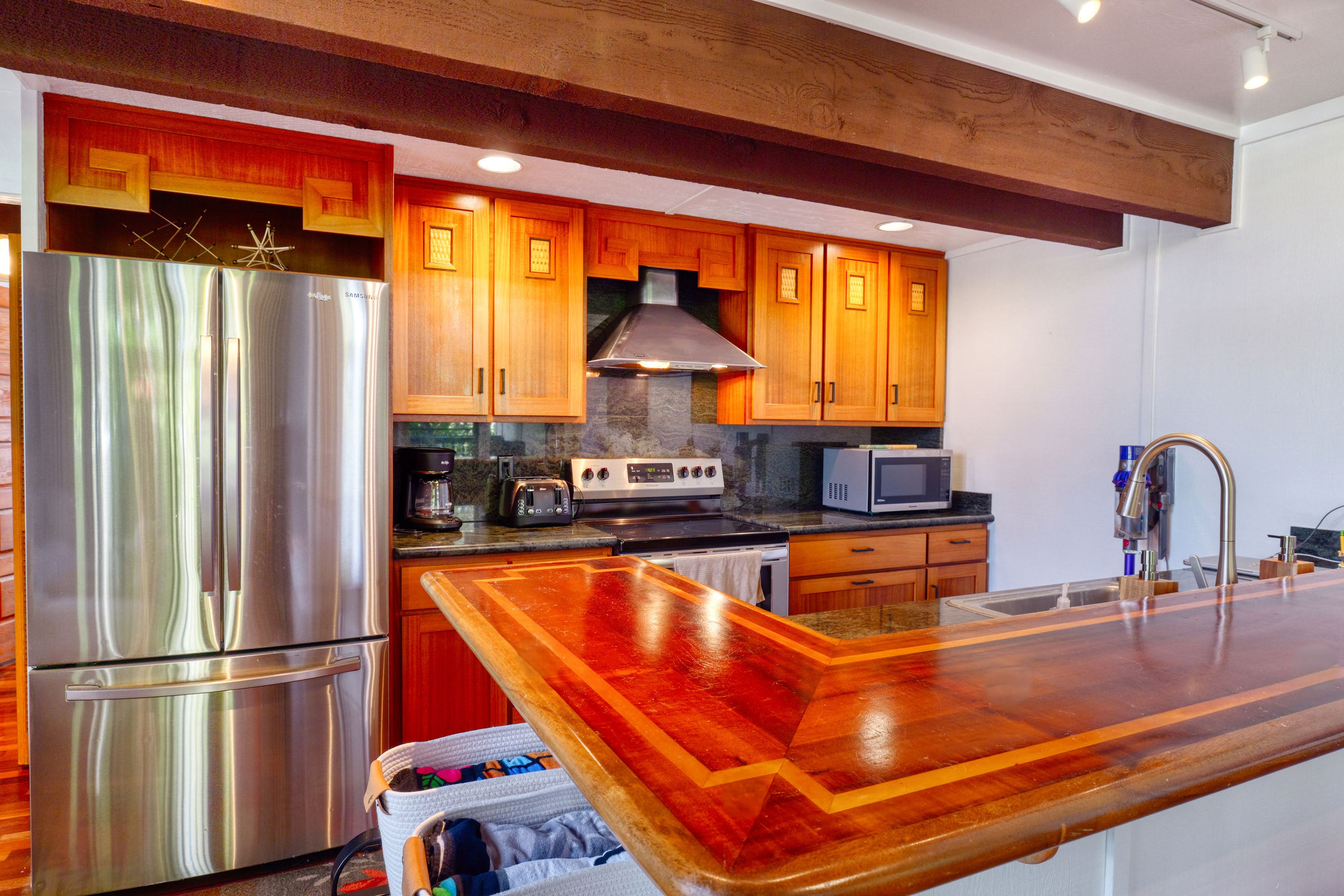 3920 Wyllie Road, Unit F20 Princeville, HI 96722 - Photo 6 of 25 a kitchen with stainless steel appliances granite countertop a refrigerator a sink and a stove