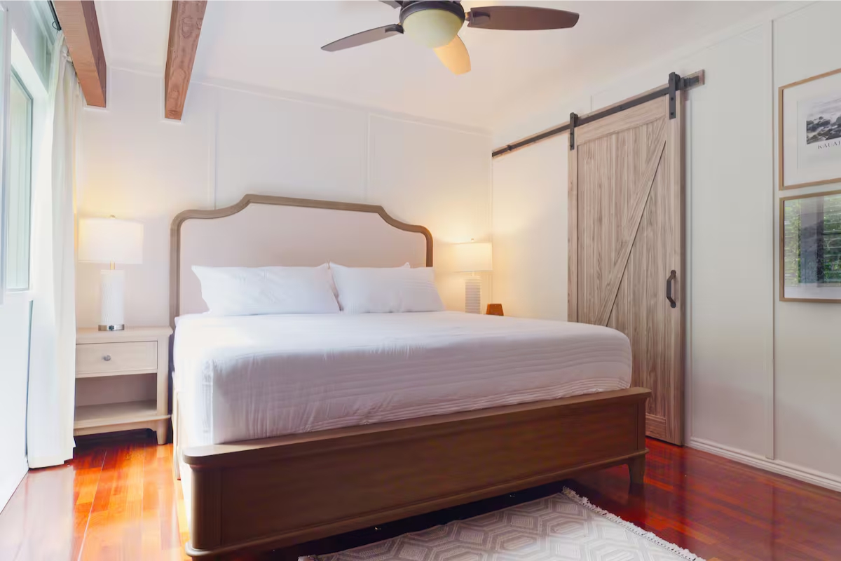 3920 Wyllie Road, Unit F20 Princeville, HI 96722 - Photo 9 of 25 a bedroom with a bed and a chandelier fan