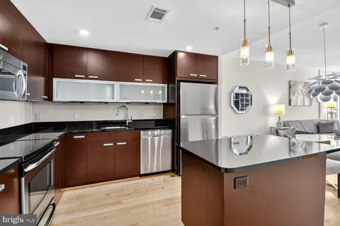 a kitchen with kitchen island a sink stainless steel appliances and cabinets