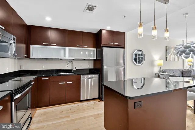a kitchen with kitchen island a sink stainless steel appliances and cabinets