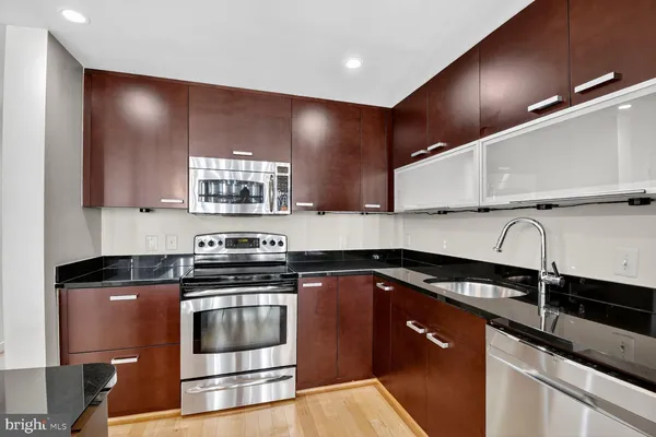 a kitchen with granite countertop a stove a sink and a microwave