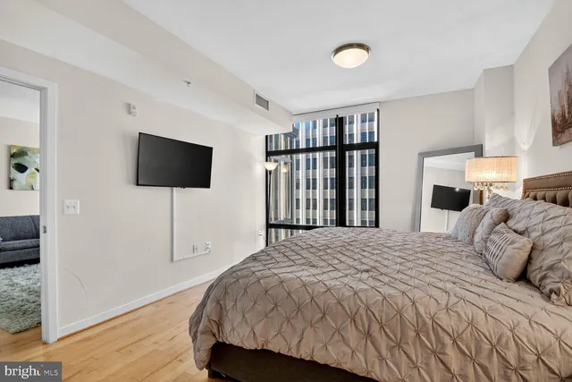 a bedroom with a bed tv and a window