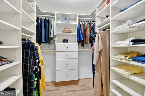a view of walk in closet with clothes and shoes