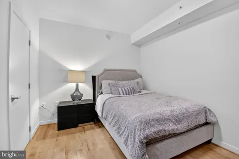 a bedroom with a bed and wooden floor