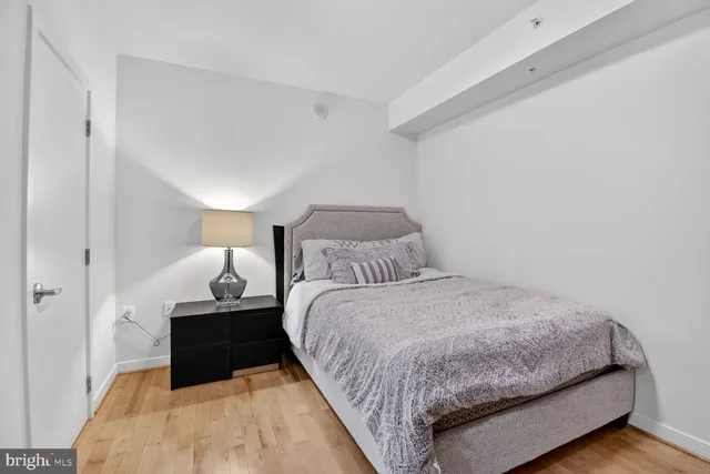 a bedroom with a bed and wooden floor