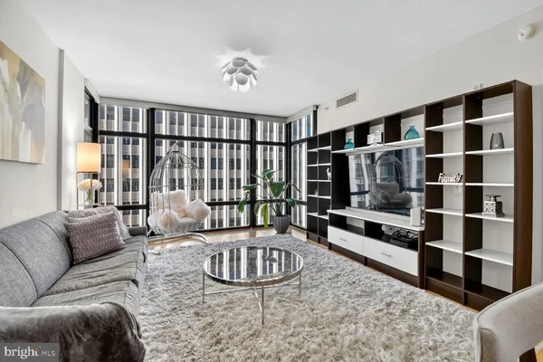a living room with furniture windows and a flat screen tv