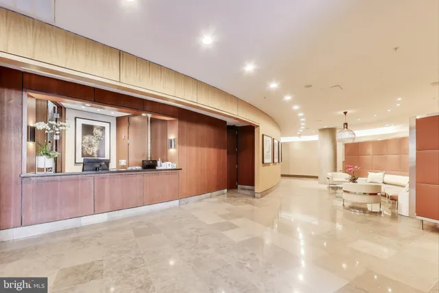 a view of a kitchen with kitchen island stainless steel appliances a refrigerator a sink and a counter top space