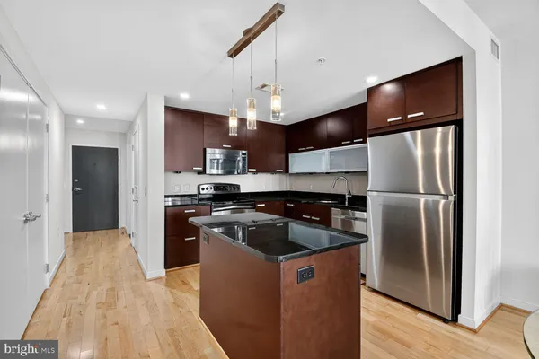 a kitchen with stainless steel appliances granite countertop a refrigerator a stove a sink and a refrigerator