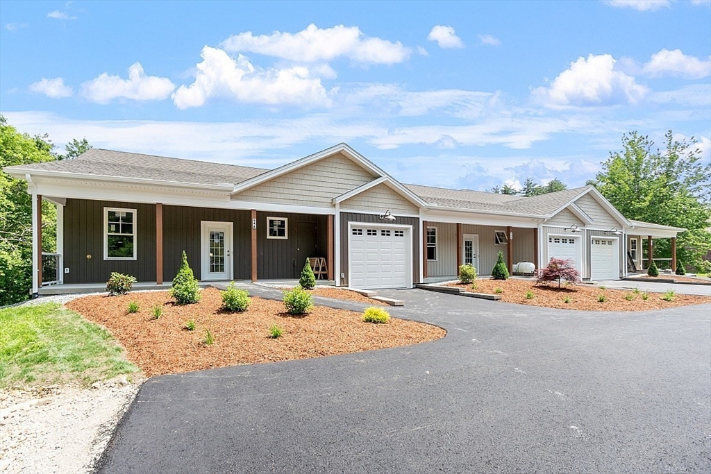 94 Fitchburg Road, Unit 3 Townsend, MA 01469 - Photo 36 of 37 a front view of a house with an outdoor space and seating area