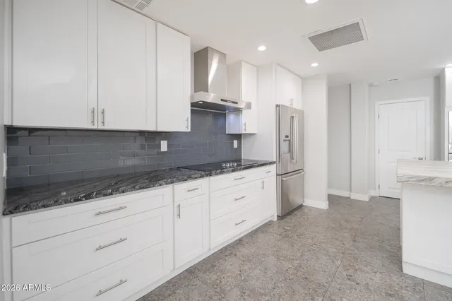 a kitchen with granite countertop white cabinets and stainless steel appliances