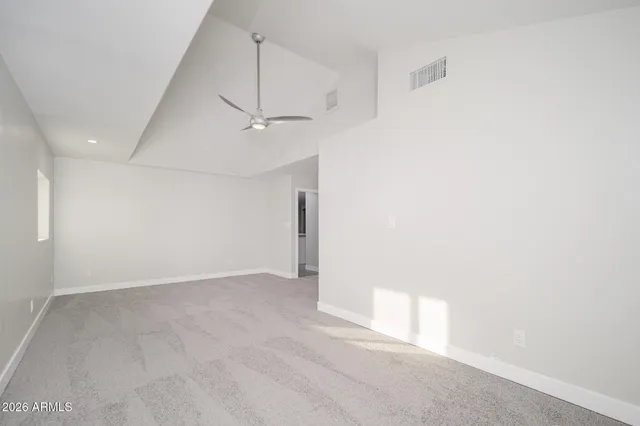 an empty room with a ceiling fan and a window