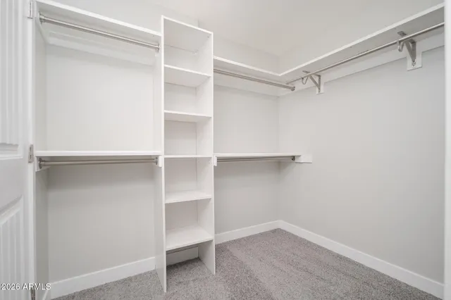 a view of walk in closet with empty racks