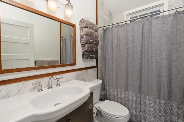 a bathroom with a sink a toilet and shower