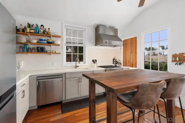 a kitchen with stainless steel appliances granite countertop a sink and a refrigerator