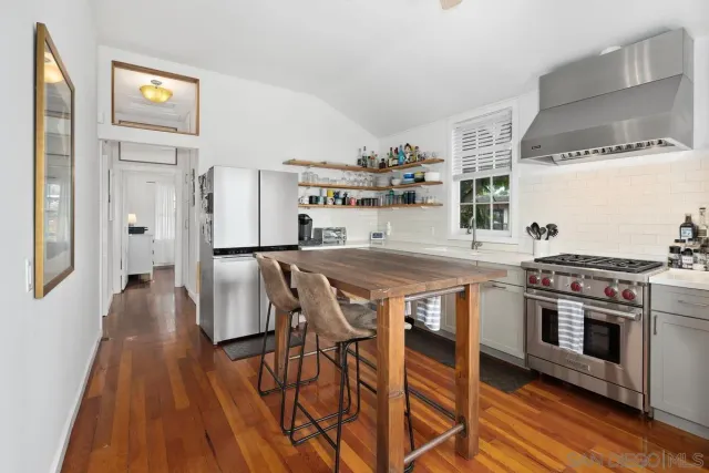 a kitchen with stainless steel appliances a stove a sink dishwasher and cabinets with wooden floor