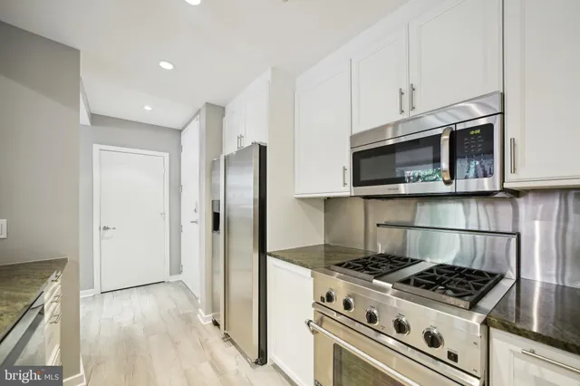 a kitchen with stainless steel appliances a stove a microwave and a refrigerator