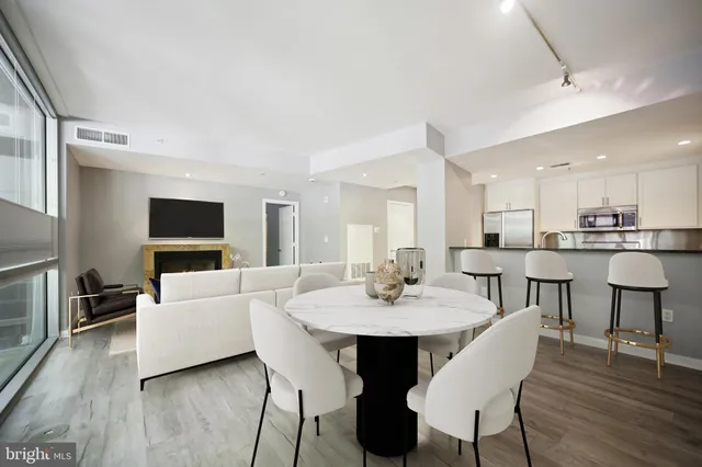 a living room with furniture and a dining table with wooden floor