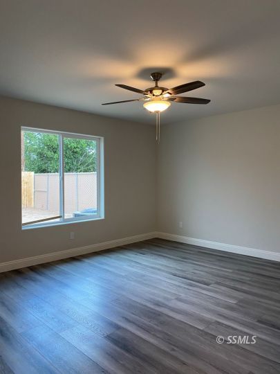 1136 West Boston Avenue Ridgecrest, CA 93555 - Photo 16 of 23 a view of an empty room with wooden floor and a window