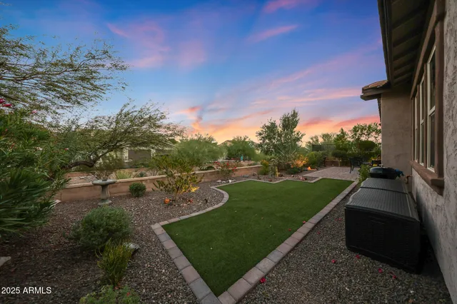 a view of a swimming pool with a garden and patio