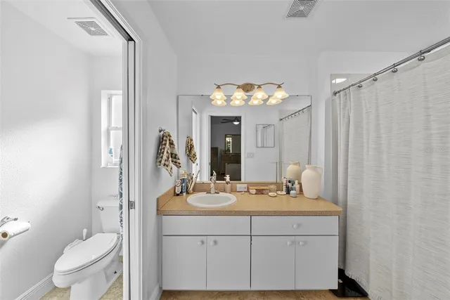 a bathroom with a double vanity sink mirror and toilet
