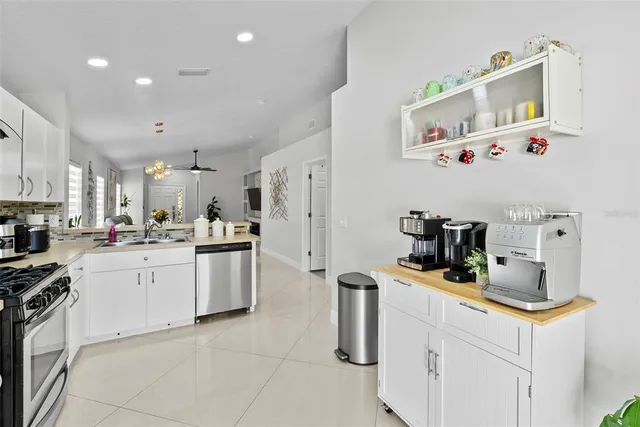 a kitchen with white cabinets and appliances