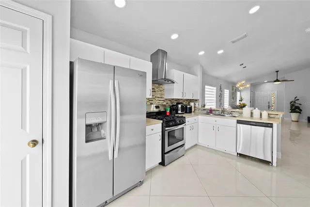 a kitchen with granite countertop white cabinets and stainless steel appliances