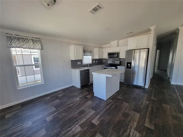 a kitchen with stainless steel appliances a refrigerator and a stove top oven