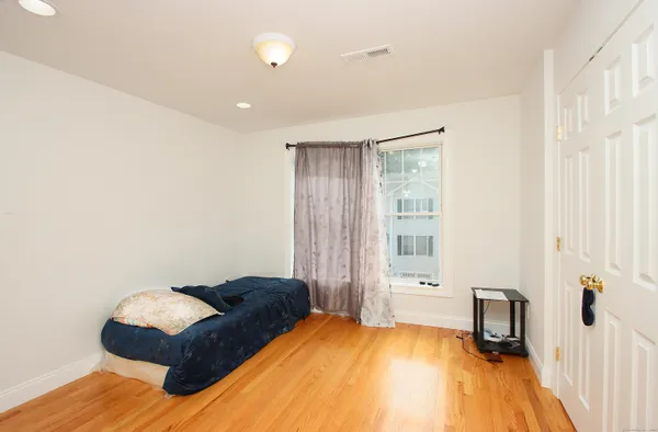 a bedroom with a bed and wooden floor