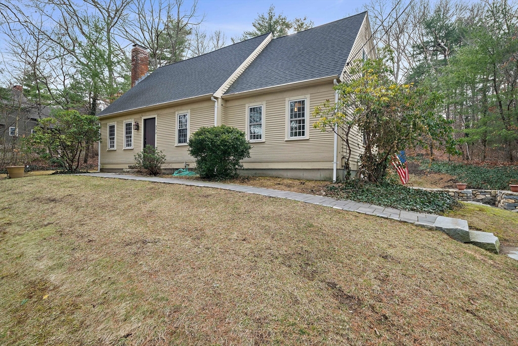 a view of a house with a yard and large tree