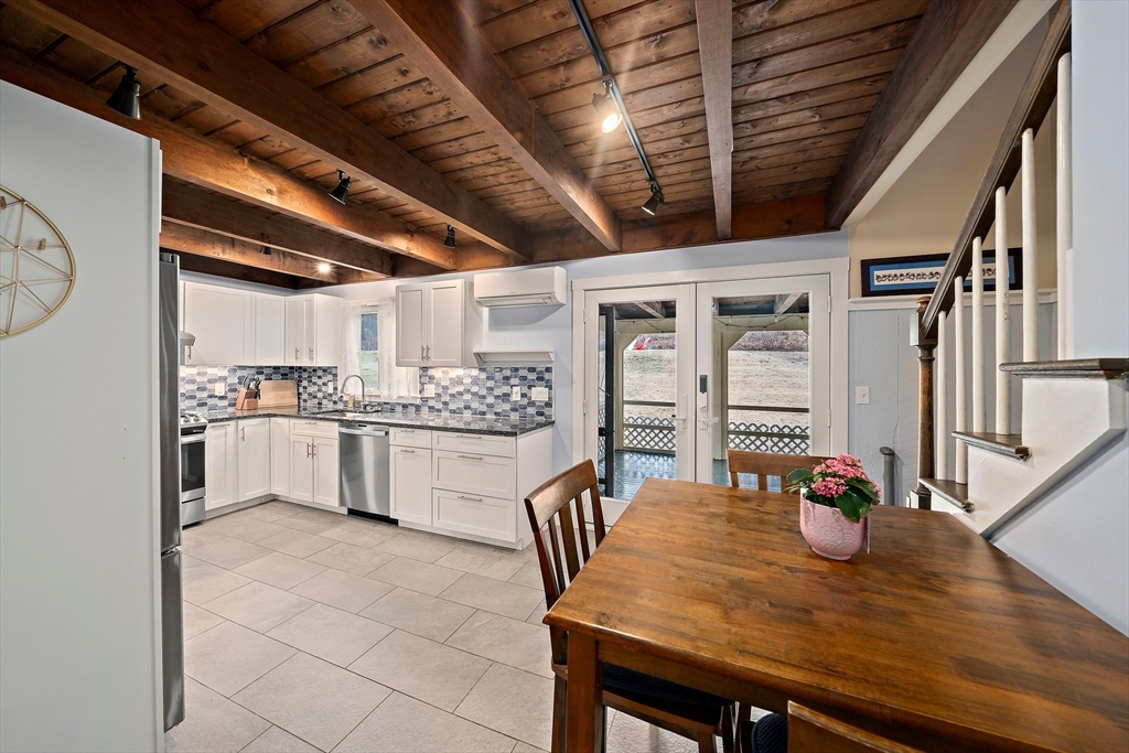 372 Winter Street Walpole, MA 02081 - Photo 11 of 42 a kitchen with stainless steel appliances granite countertop a sink window and cabinets