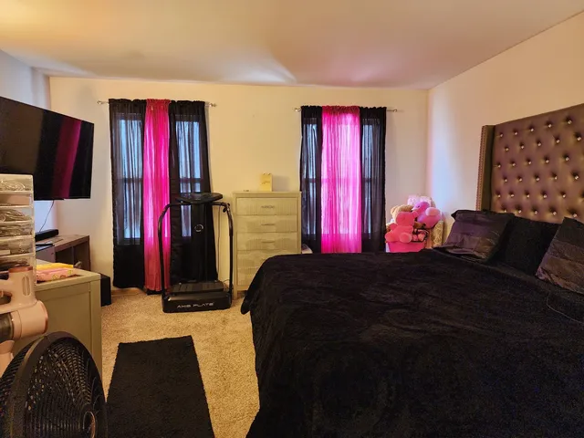 a bedroom with a bed closet and a flat tv screen