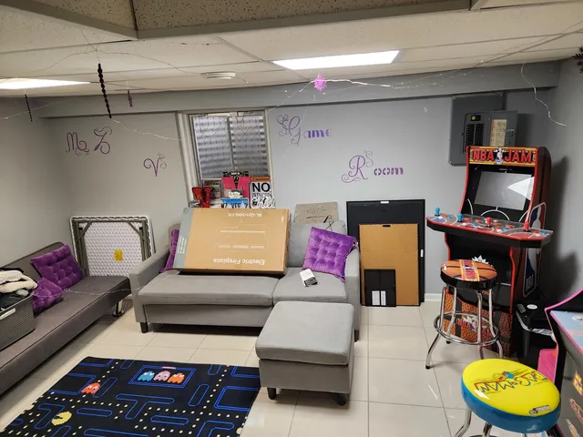 a living room with furniture and a baby crib