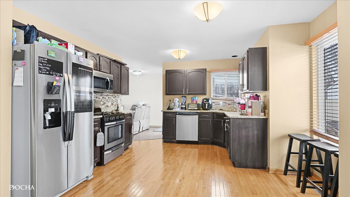 2216 Beechwood Road Joliet, IL 60432 - Photo 8 of 21 a kitchen with stainless steel appliances kitchen island granite countertop a refrigerator stove microwave and sink
