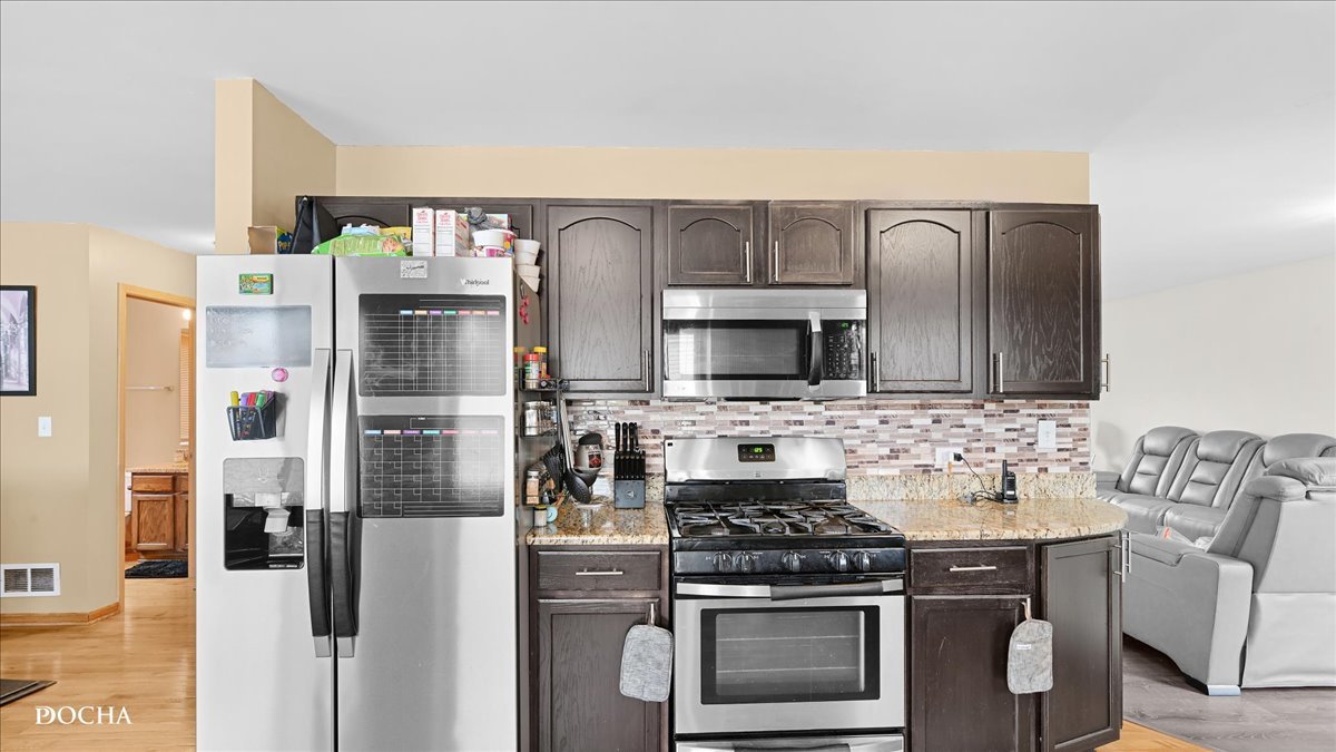 2216 Beechwood Road Joliet, IL 60432 - Photo 9 of 21 a kitchen with stainless steel appliances a stove a microwave and a refrigerator