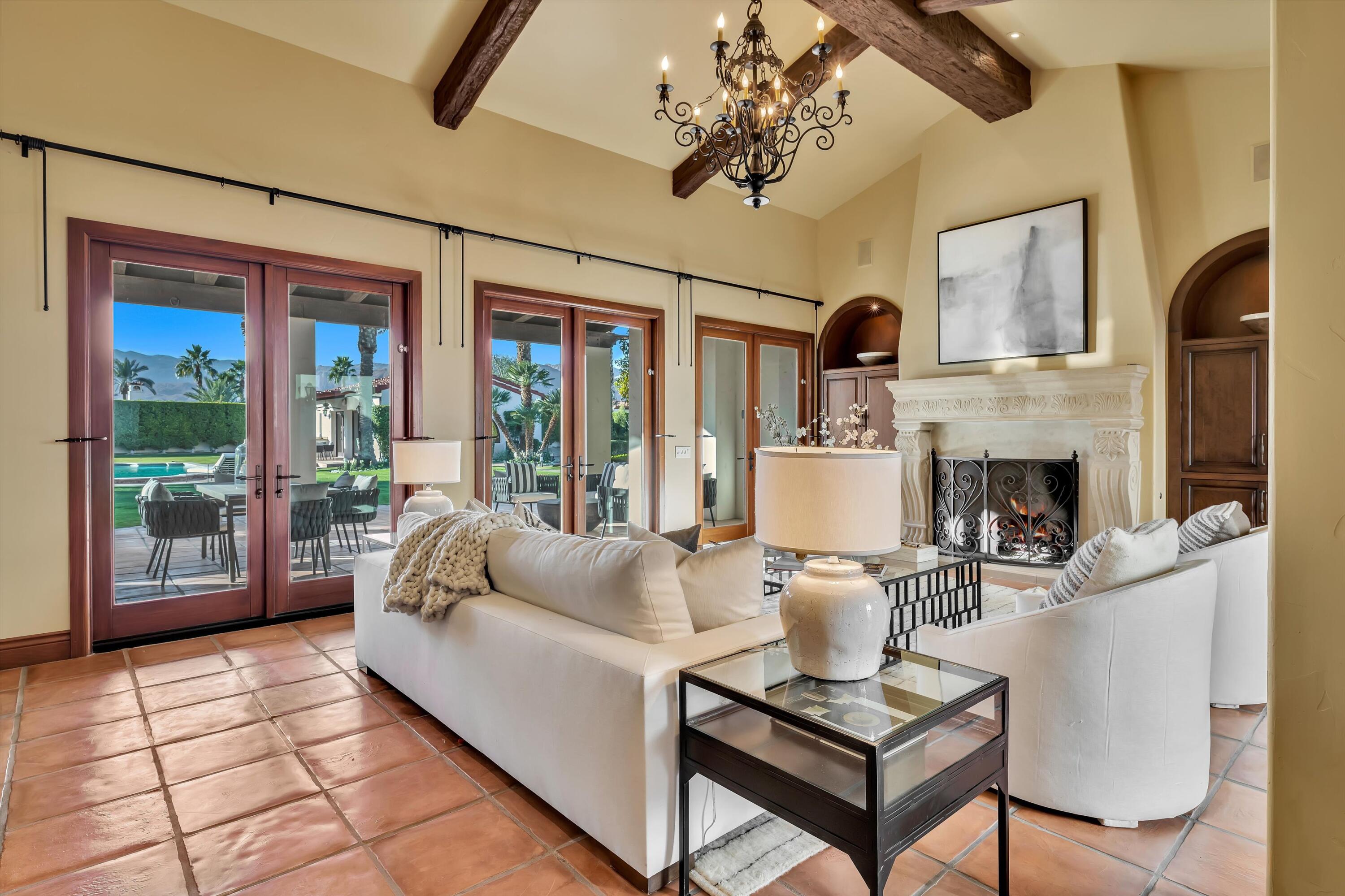 2 Serrano Way Rancho Mirage, CA 92270 - Photo 33 of 76 a living room with furniture a fireplace and a chandelier