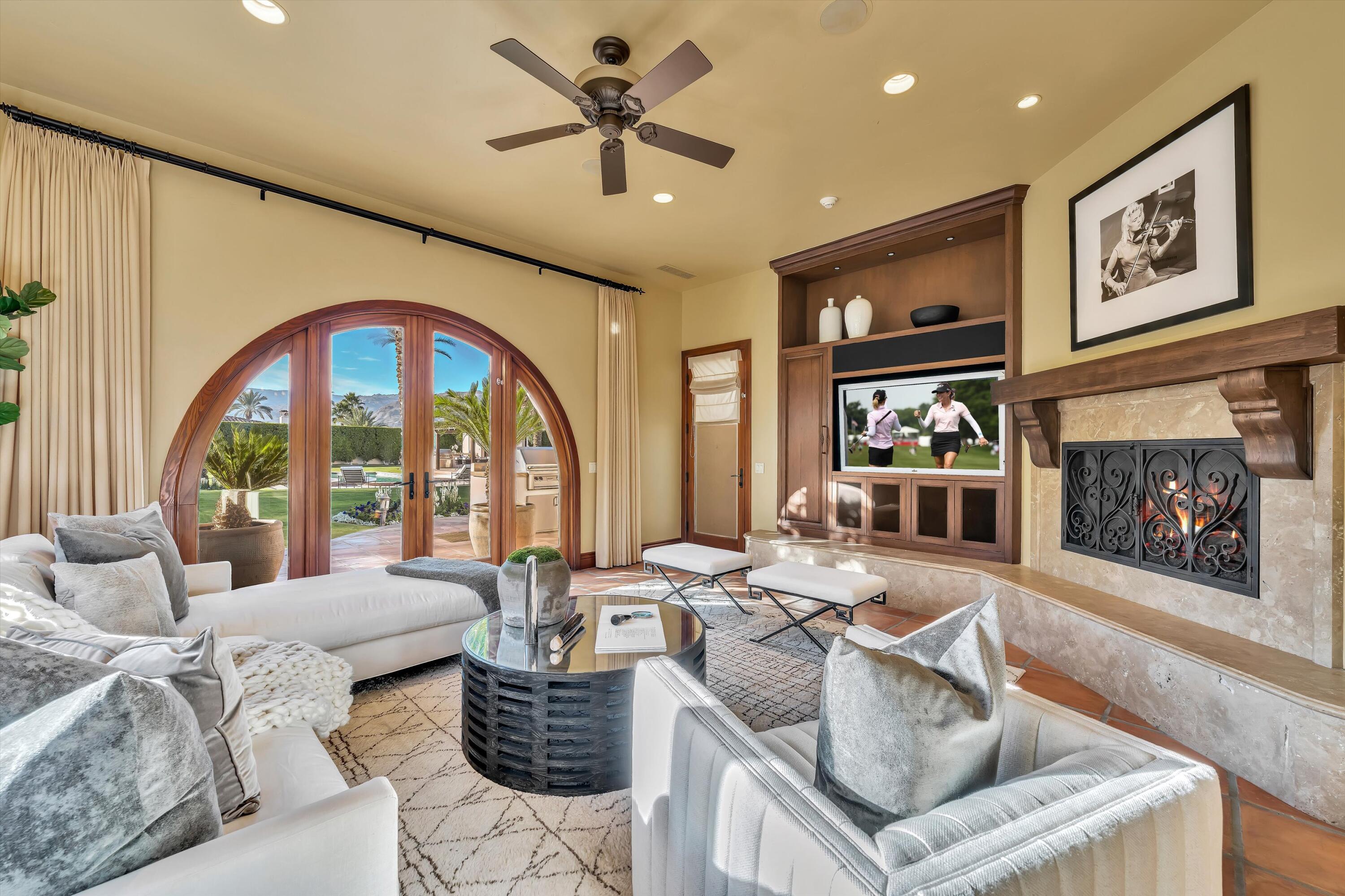 2 Serrano Way Rancho Mirage, CA 92270 - Photo 42 of 76 a living room with furniture a fireplace and a large window