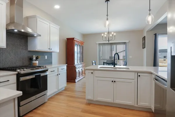 a kitchen with stainless steel appliances granite countertop a sink stove and refrigerator