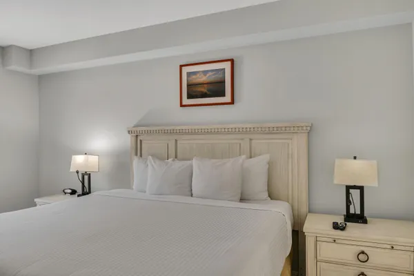 a bedroom with a bed and a lamp on dresser