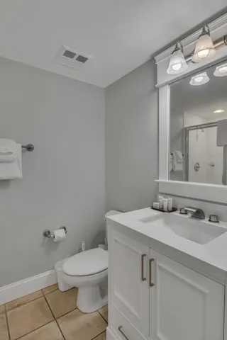 a bathroom with a sink a toilet and a mirror