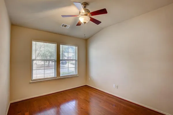 an empty room with windows and fan