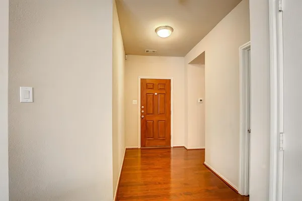 a view of a hallway with wooden floor