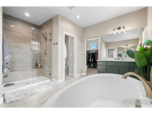 a bathroom with a bathtub shower sink and mirror