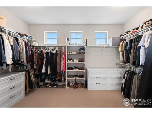 a view of walk in closet with clothes