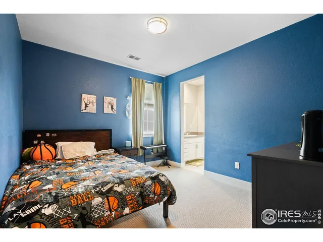 a bedroom with a bed and a flat tv screen on dresser