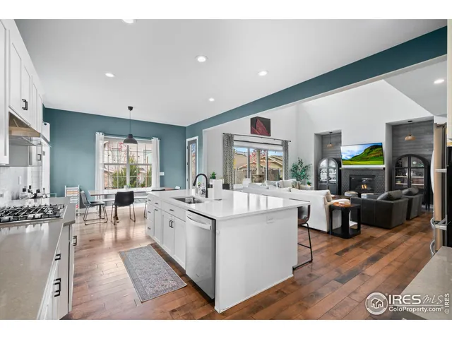 a large living room with stainless steel appliances kitchen island granite countertop a large window and a couch