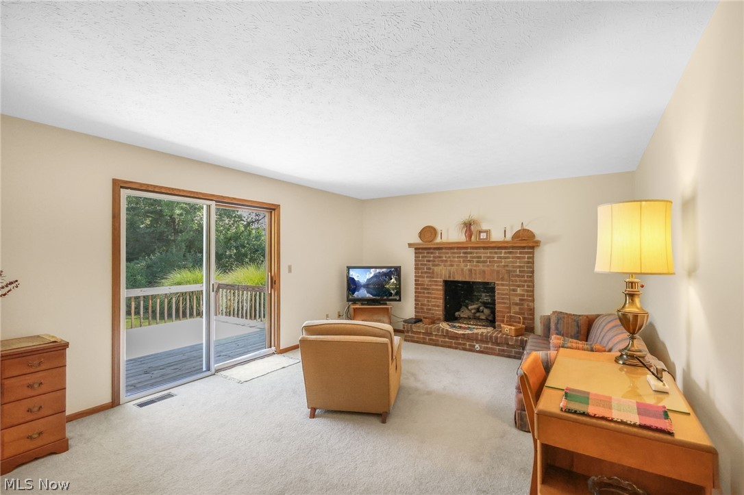 155 Oldman Road Wooster, OH 44691 - Photo 11 of 37 Living room with a textured ceiling, light carpet, and a fireplace