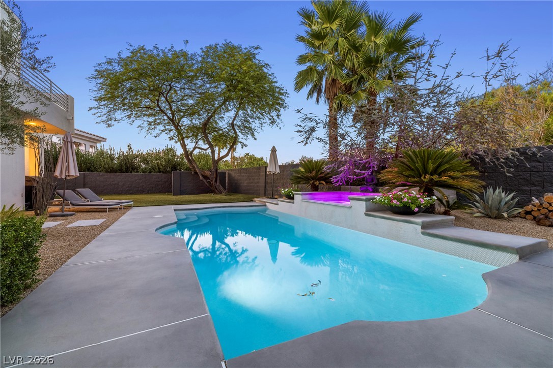 2000 Grouse Street Las Vegas, NV 89134 - Photo 59 of 89 An inviting backyard oasis offers a sparkling in-ground pool and integrated spa, surrounded by verdant landscaping.